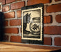 A black and white illustration of a cat sitting on a wooden surface, looking at a fish in a glass bowl.