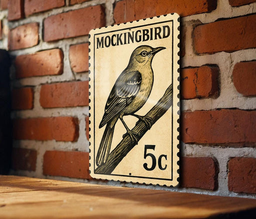 A vintage postage stamp featuring a bird, likely a Mockingbird, is displayed on a brick wall.