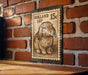 A metal stamp featuring a rabbit on a brick wall.