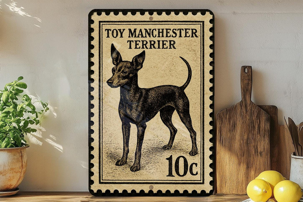 A vintage-style metal stamp depicting a toy Manchester Terrier, with the text "TOY MANCHESTER TERRIER" and a value of 10 cents.