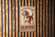 A metal sign with a picture of a beagle dog and the text "TREING WALKER COONHOUND" is displayed on a wooden fence.