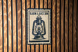 A barn lantern sign is displayed on a wooden wall.