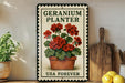 A vintage-style metal sign with a potted geranium plant on it, placed on a wooden shelf next to a wooden cutting board and some lemons.