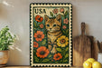 A metal stamp with a cat illustration on it, surrounded by flowers, is displayed on a shelf next to a wooden cutting board and some potted plants.
