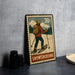 A metal stamp depicting a person snowshoeing, with a mountain landscape in the background.