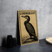 a framed illustration of a cormorant bird, which is a type of sea bird, sitting on a rock.
