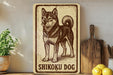 A vintage-style sign featuring a drawing of a Shikoku dog, a breed of Japanese Shiba Inu, is displayed on a shelf next to a wooden cutting board and some kitchen utensils.
