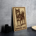 A wooden sign featuring a drawing of a Shikoku dog, a breed of Japanese Shiba Inu dogs, is displayed on a table.