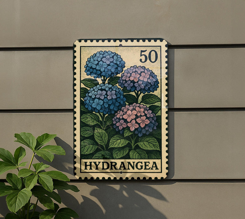 A metal sign with a floral design, featuring blue and pink hydrangea flowers, mounted on a wall.