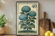 A framed illustration of three blue hydrangea flowers is displayed on a shelf, accompanied by a wooden cutting board and a potted plant.