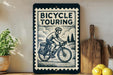 a bicycle touring sign with a black and white illustration of a person riding a bicycle, placed on a wooden surface next to a wooden cutting board and some lemons.