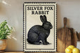 A sign featuring a silver fox rabbit illustration is displayed on a shelf next to a wooden cutting board and a potted plant.