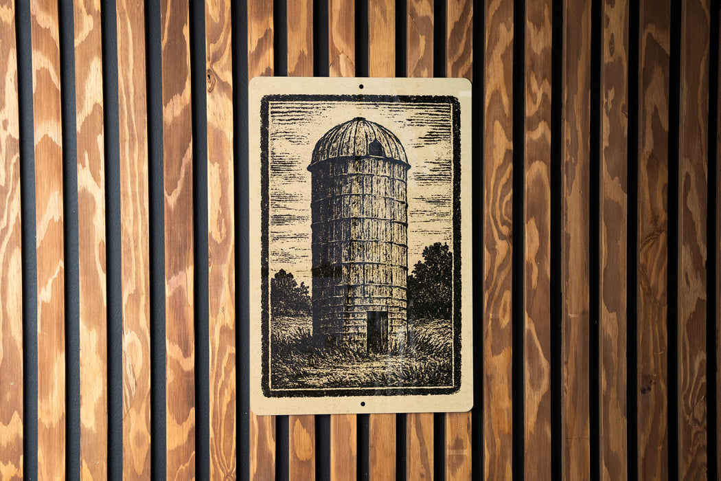 a wooden wall with a framed illustration of a tall cylindrical structure, resembling a barn or silo, mounted on it.