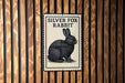 A silver fox rabbit illustration is displayed on a wooden wall.