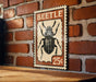 A vintage-style postage stamp featuring a detailed illustration of a beetle, with the word "BEETLE" prominently displayed.