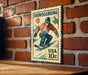 A vintage-style metal stamp depicting a snowboarder on a mountain slope, with the text "SNOWBOARDING" and "USA 10c" printed on it.