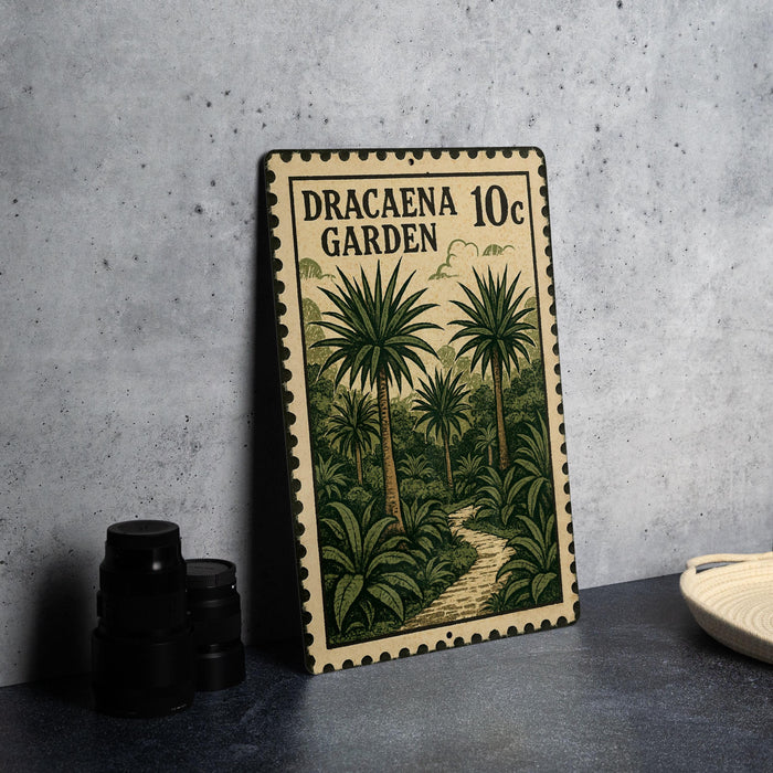 A metal sign with a tropical garden scene, featuring palm trees and a winding path, is displayed on a table next to some black camera lenses.