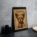 A framed image of a dog, resembling a postage stamp, is displayed on a table.
