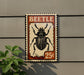 A vintage-style metal sign featuring a black beetle illustration, mounted on a wall.