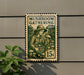 A metal sign with a stamp-like design hangs on a wall, featuring an illustration of a person holding mushrooms and the text "MUSHROOM GATHERING".