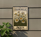 A metal sign with a floral design hangs on a wall, displaying the text "CHAMOMILE PATCH".