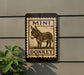 a sign with a donkey illustration, mounted on a wall.