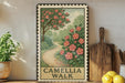 a framed illustration of a garden path with a tree and pink flowers, placed on a shelf next to a wooden cutting board and a potted plant.