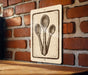 a sign with a drawing of three spoons on a brick wall.