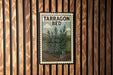A vintage-style metal sign with the text "TARRagon BED" is displayed on a wooden wall.