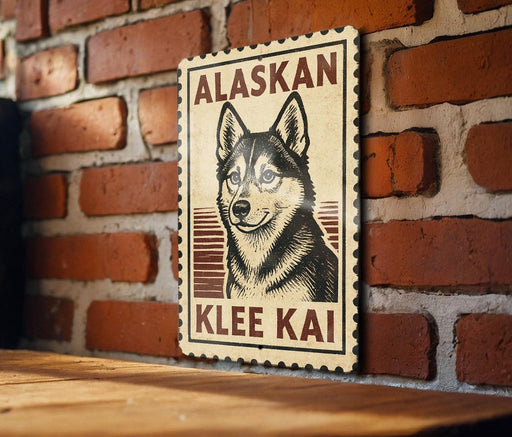 A wooden table with a wooden border, against a brick wall. There is a framed poster of a dog, specifically an Alaskan Klee Kai, hanging on the wall.