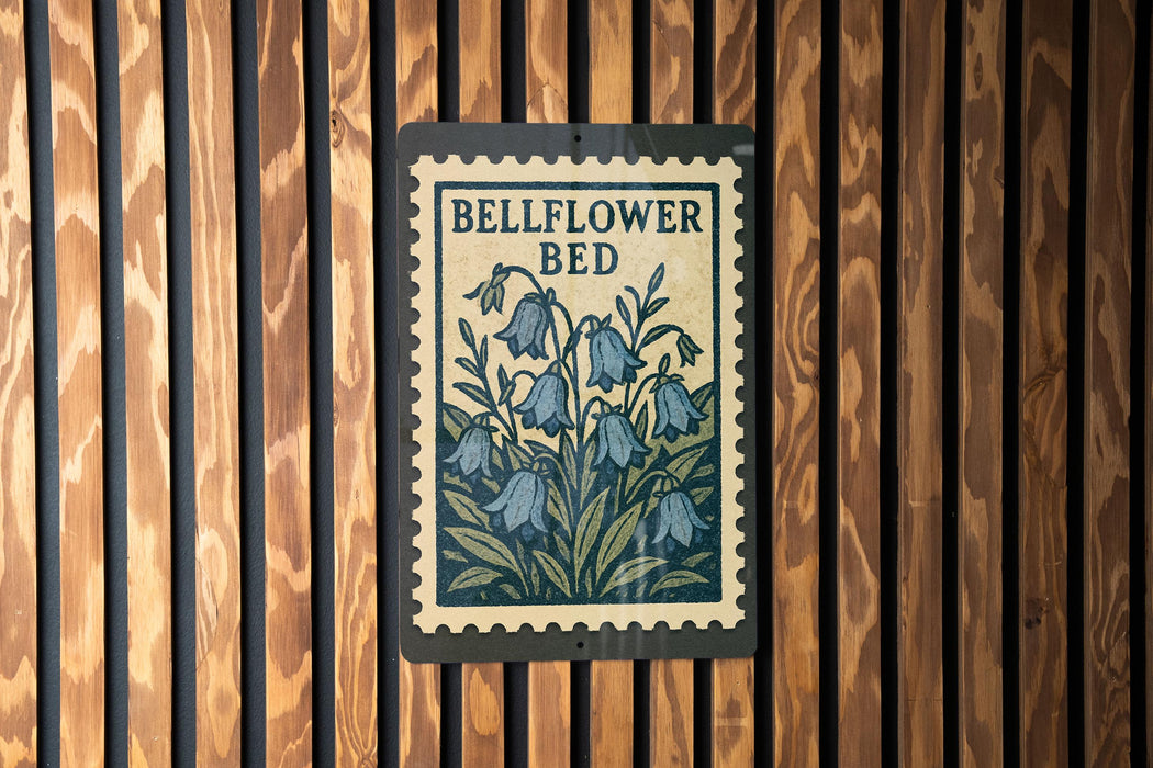 A sign with the text "BELLFLOWER BED" and an illustration of blue flowers is hanging on a wooden wall.