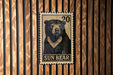 A metal stamp featuring a black and white illustration of a bear, with the text "SUN BEAR" below it.