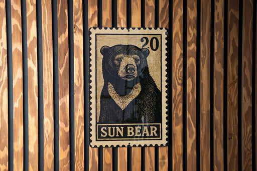 A metal stamp featuring a black and white illustration of a bear, with the text "SUN BEAR" below it.