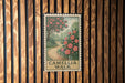 A framed sign with a floral illustration of a path leading through a garden, mounted on a wooden wall.