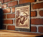 a sign with a crossbow and the text "CROSSBOW SHOOTING" on a brick wall.