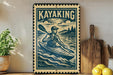 A vintage-style metal sign with a kayaker illustration, placed on a wooden surface next to a potted plant and a cutting board.