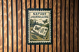 A nature-themed poster or stamp with the title "NATURE JOURNALING" and illustrations of butterflies and plants.