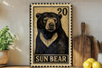 a wooden cutting board with a potted plant to the left and a framed image of a black bear to the right.