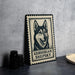 A framed image of a Gerberian Shepsky dog, a breed of sled dogs, is displayed on a table.