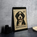 A framed image of a Bernedoodle dog, a breed of small, curly-haired, mixed-breed dog, is displayed on a black surface.