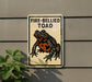 a sign with a picture of a fire-bellied toad on it, mounted on a wall.