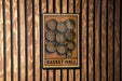 a sign with the text "Basket Wall" and a design of concentric circles on a wooden background.