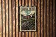 A vintage-style metal sign with a farm scene and a barn, mounted on a wooden wall.