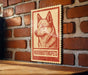 a sign with a dog illustration on it, mounted on a brick wall.