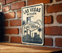 A vintage-style sign for Las Vegas, Nevada, mounted on a brick wall.