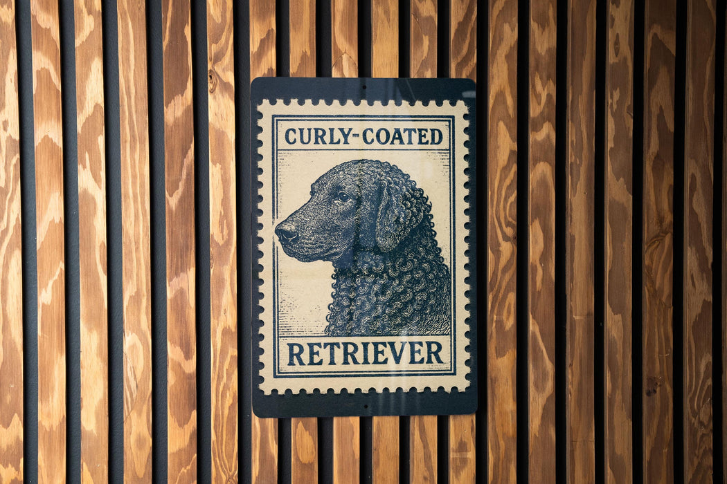 A curly-coated retriever dog is depicted on a black and white postage stamp, which is mounted on a wooden wall.