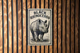 a rhinoceros, which is a large horned mammal, mounted on a wooden wall.