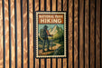 A vintage-style poster of a hiker with a backpack, set against a wooden background with vertical slats.