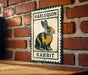 A metal sign with a cartoon rabbit on it is hanging on a brick wall.