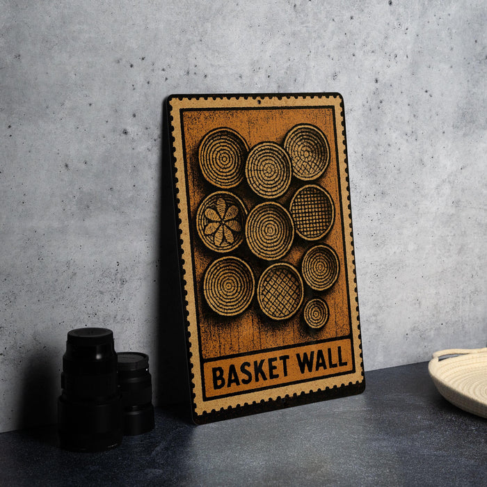 A wooden sign with a design of baskets and the text "Basket Wall" is displayed on a countertop next to some black camera lenses.